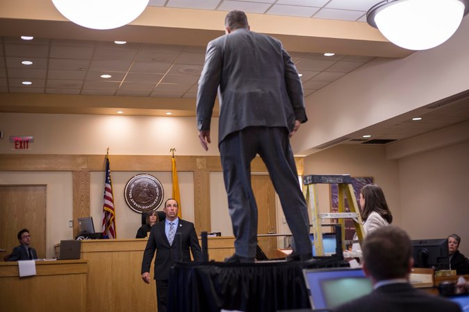 A man standing on a table in a courtroom