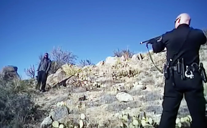 A police officer pointing a gun at a criminal